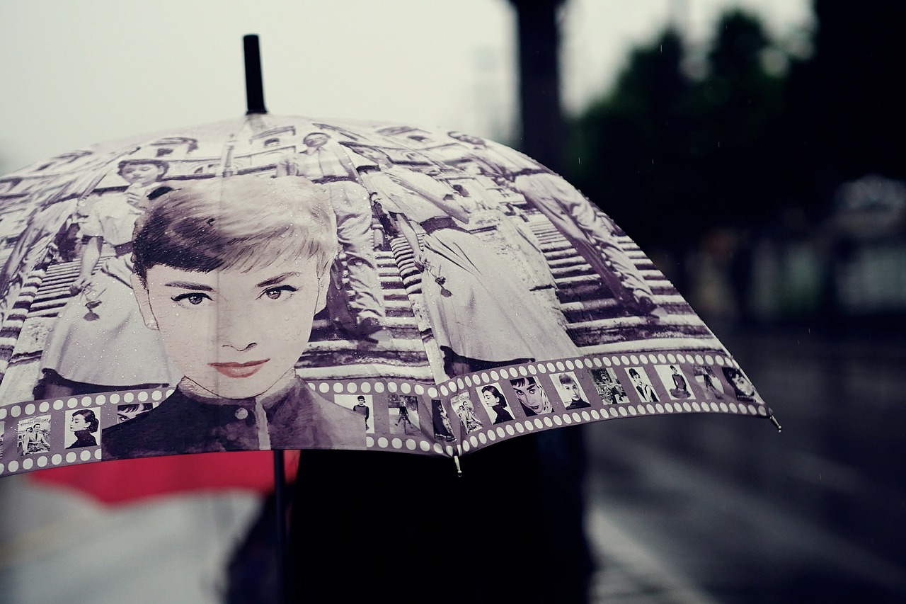 A young woman holding a beautiful umbrella in the rain